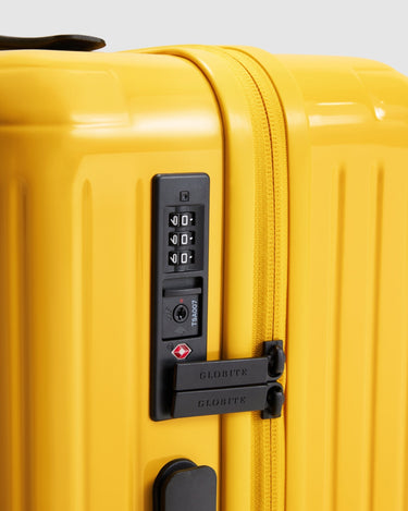 Yellow carry on suitcase closeup of TSA approved lock